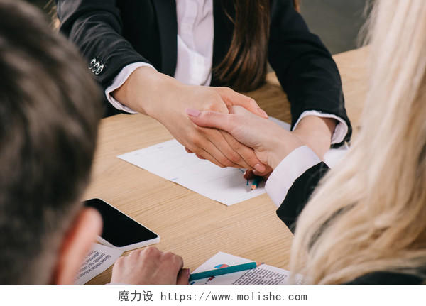 两位女商人在办公室里握手签约成功合作合作团结握手企业团结团结人物合作平台商务人士合作握手